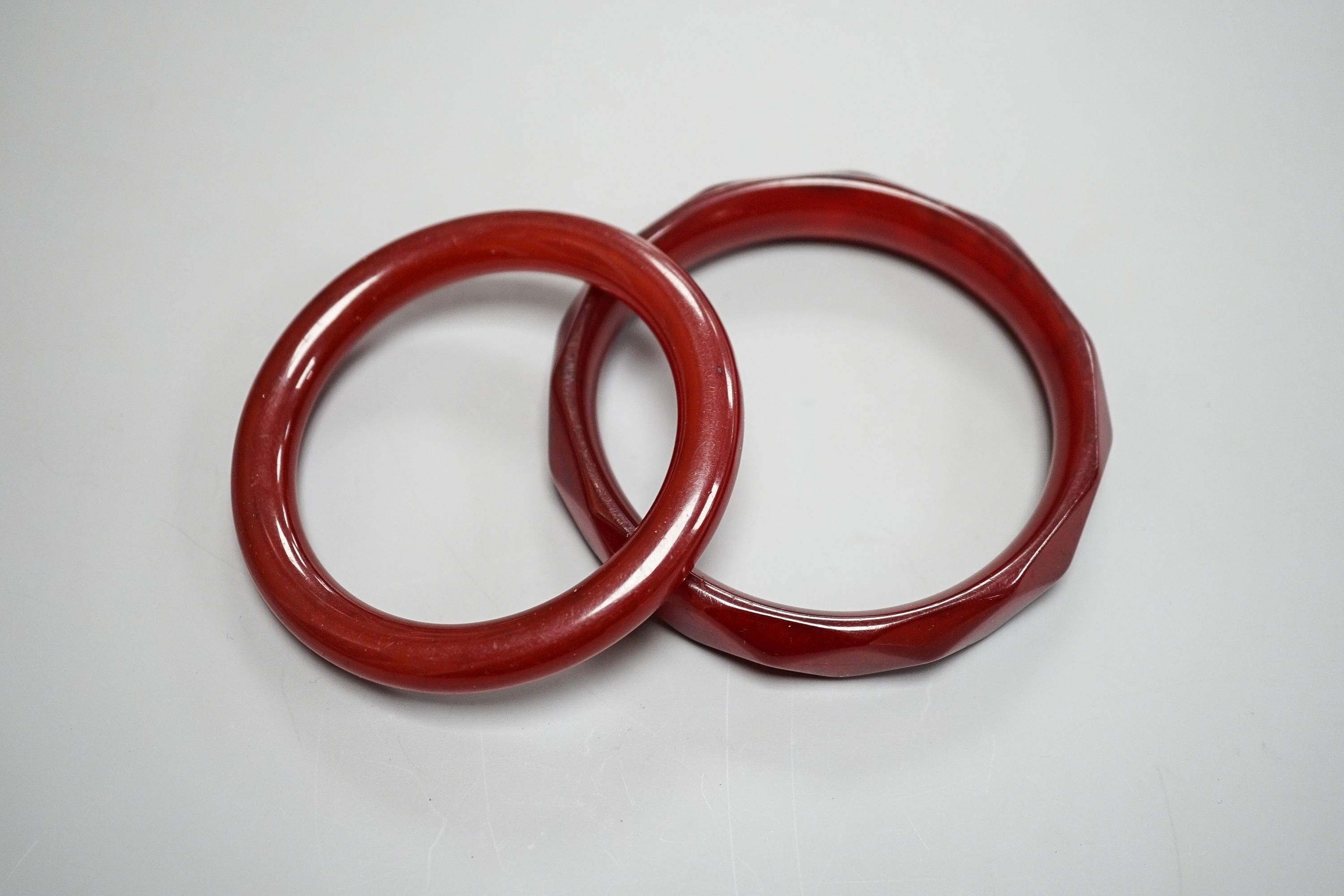 Two cherry amber bangles, gross weight 53 grams.
